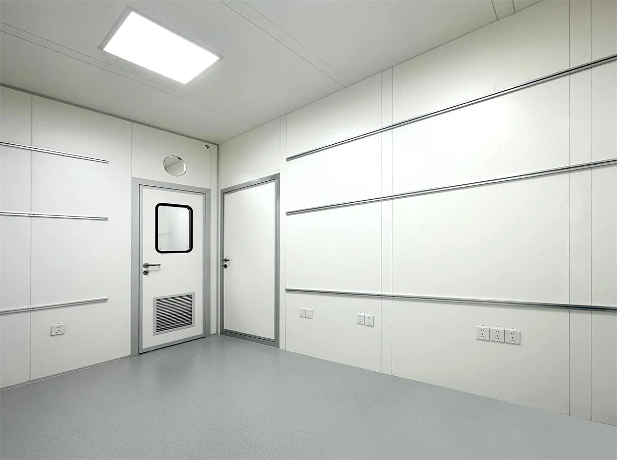 Interior of an electronics cleanroom with smooth antistatic wall panels, a cleanroom door and flush ceiling lighting