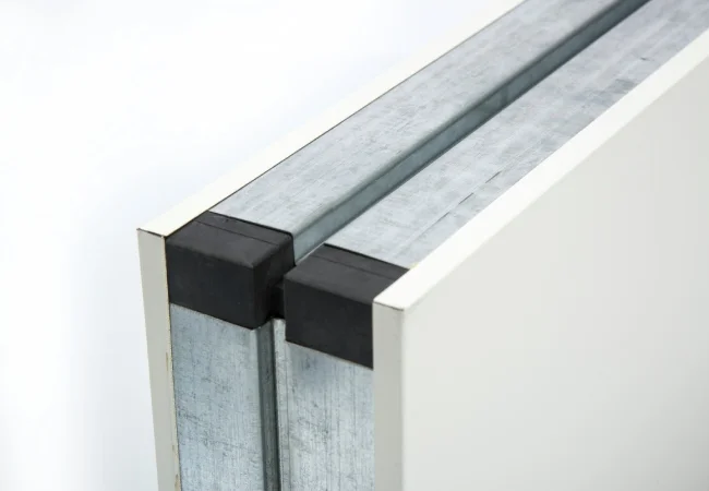 Real cleanroom wall panel edge detail showing metal skins and joint interface