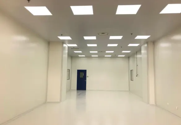 Wonclean real project photo showing a long cleanroom room with continuous wall panels, ceiling lights and a cleanroom door