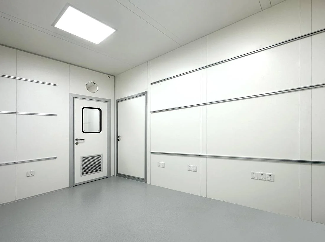 Prefabricated GMP cleanroom interior with flush HPL wall panels, coved junctions, a sealed door with vision window and a low-wall return-air grille