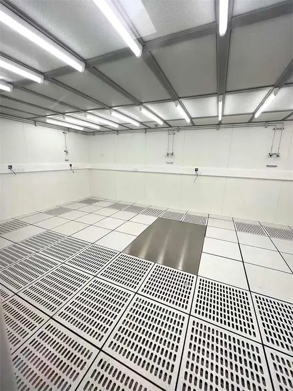 Cleanroom interior with grid ceiling lighting and a perforated raised floor for airflow return